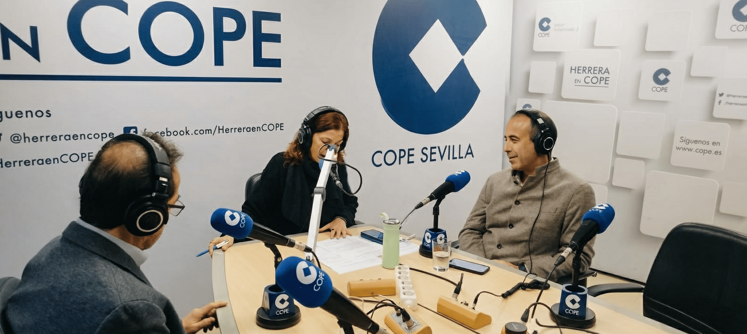 Fotografía del doctor Pedro Morales durante su entrevista en el estudio de radio de COPE Sevilla. Aparece sentado frente a los micrófonos dialogando con los presentadores del programa.